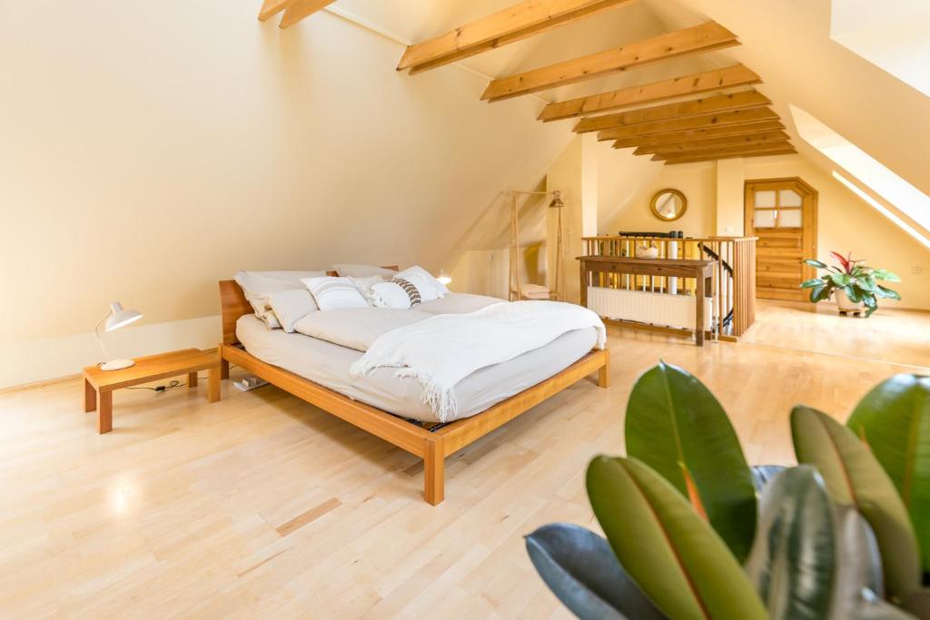 a bedroom with a bed with white sheets and a staircase at Weissenbacherhof in Oslip