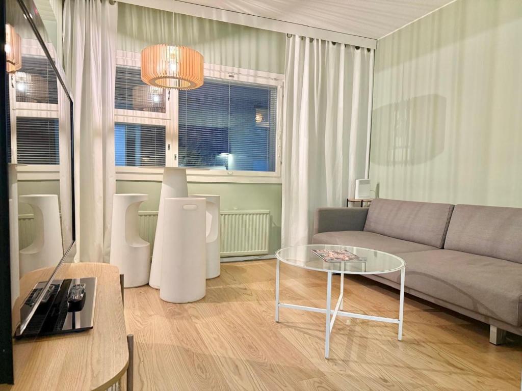 a living room with a couch and a table at Ellis Seaside Suite in Helsinki