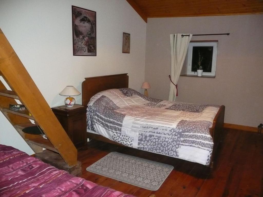 a bedroom with two beds and a window at Maison d'Hôtes LA JEANCOISE in Nonville