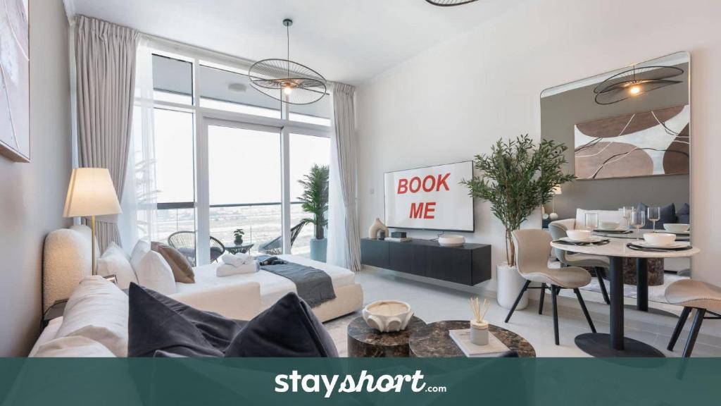ein Wohnzimmer mit Sofa und Tisch in der Unterkunft StayShort - Spacious Carson C Studio in Damac Hills in Dubai Marina