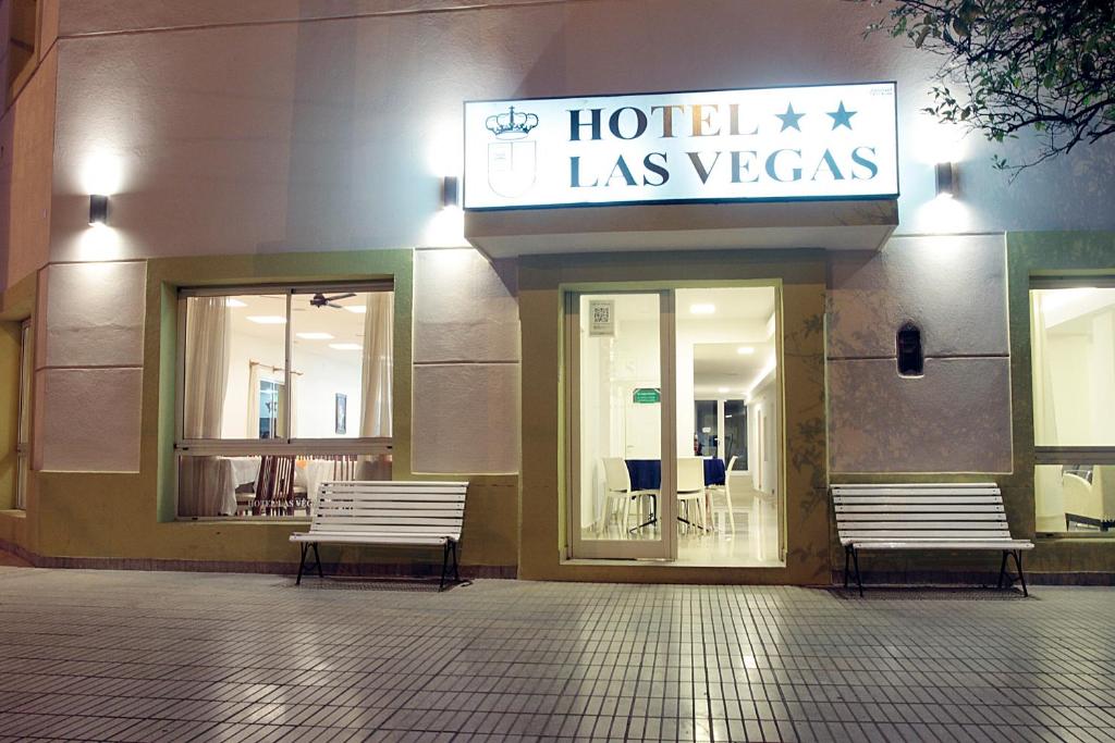 un hotel con dos bancos frente a un edificio en Las Vegas Hotel Termal en Termas de Río Hondo