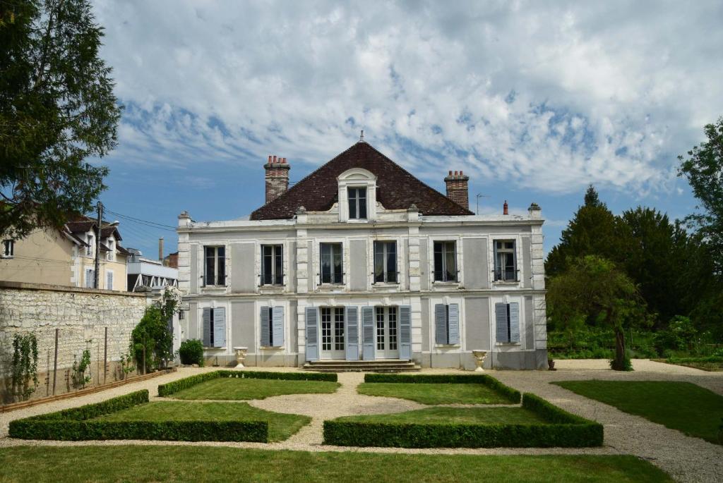a large white house with a garden in front of it at Hotel Particulier La Gobine in Joigny