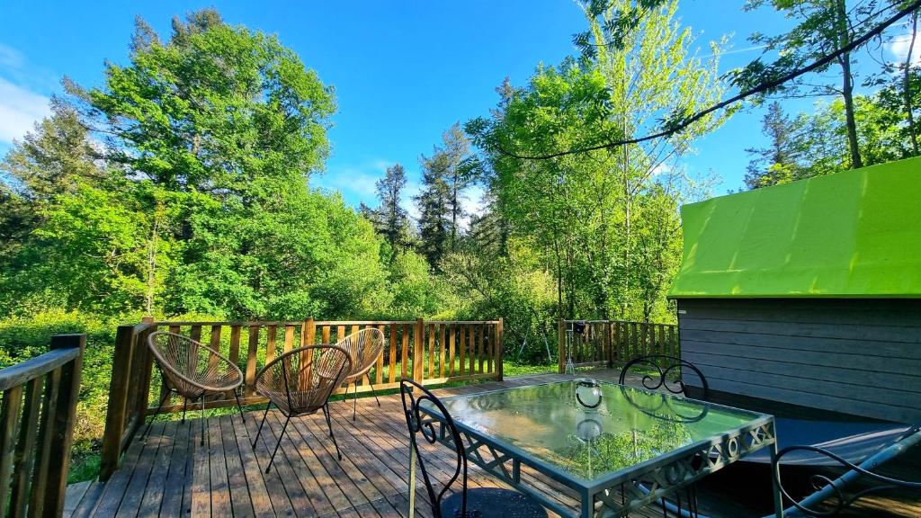 a patio with a table and chairs on a deck at Logements Insolites, Les Rêves d'Ambre 
