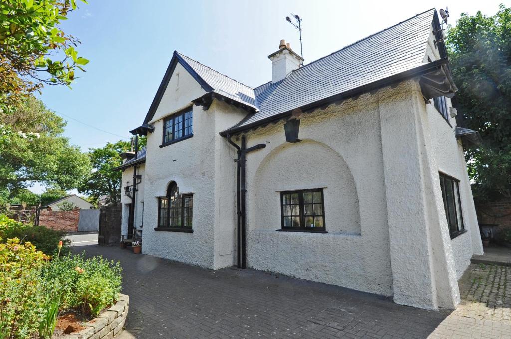 a white building with a large window at Seaways Cottage Hoylake in Hoylake