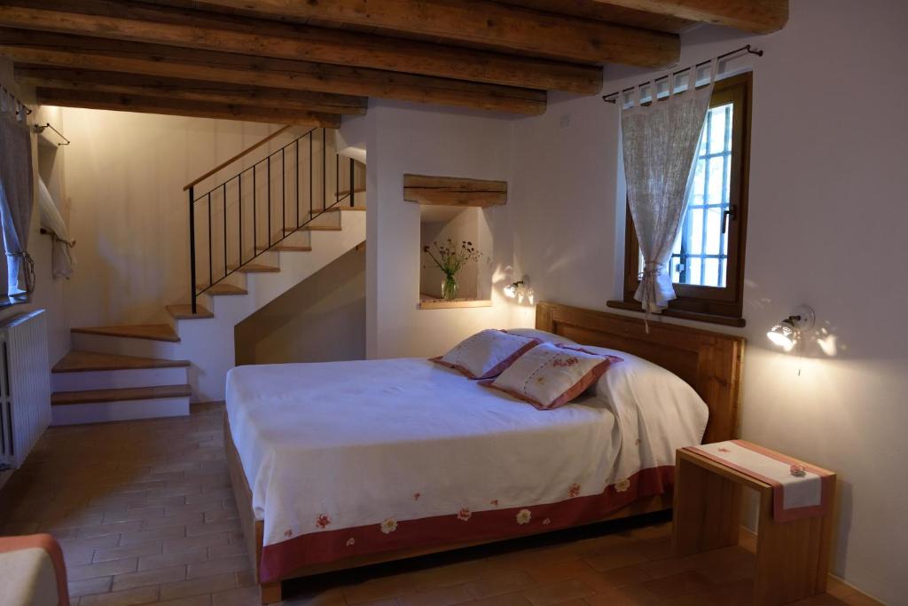 1 dormitorio con 1 cama y escalera en Giardino Sospeso Agriturismo, en Valdobbiadene