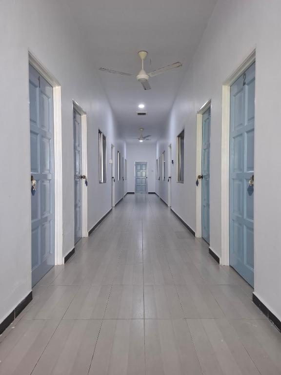Guesthouse Sungai Musoh في بينجرانج: ممر فارغ بجدران بيضاء وسقف