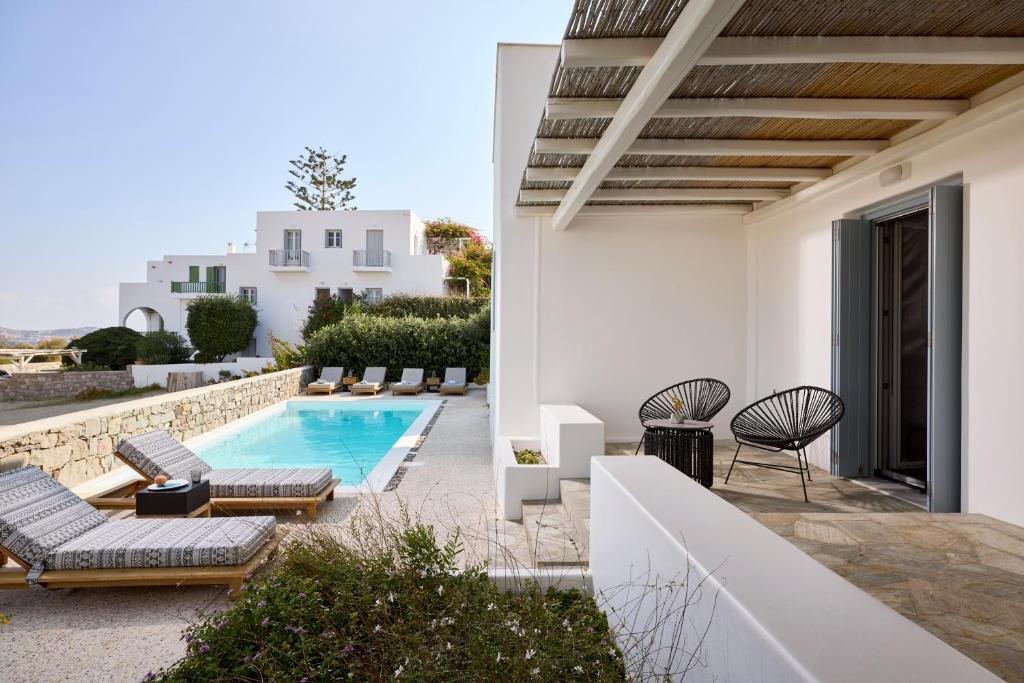 a villa with a swimming pool and a patio at Manesis Suites in Pollonia