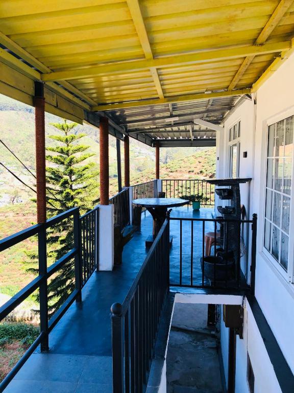 a porch with a wooden roof and tables on it at Top view cottage in Nuwara Eliya