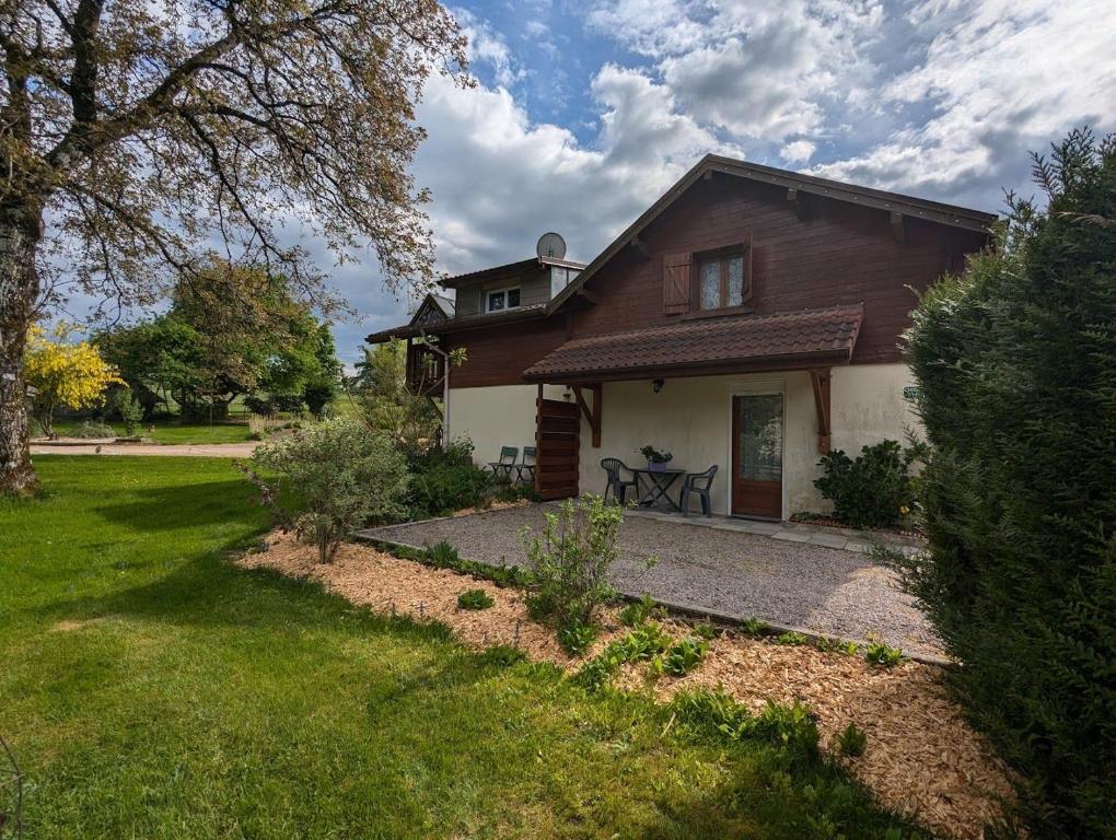 a house with a grass yard and a house at Chambre d'hôtes du Moineau in Le Val-dʼAjol