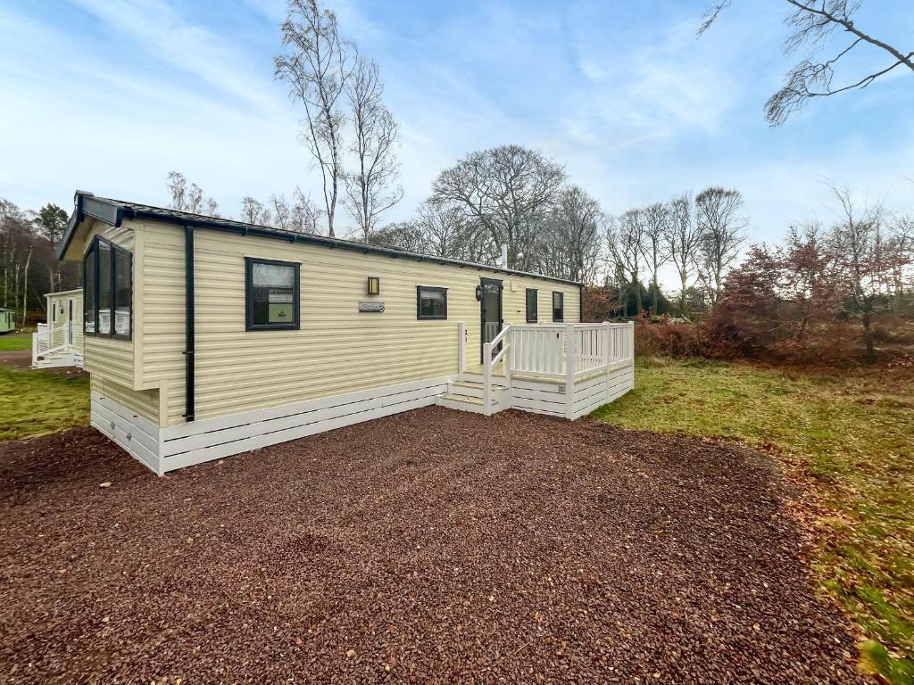 a mobile home in a field with a driveway at Jordana Lodge in Edzell
