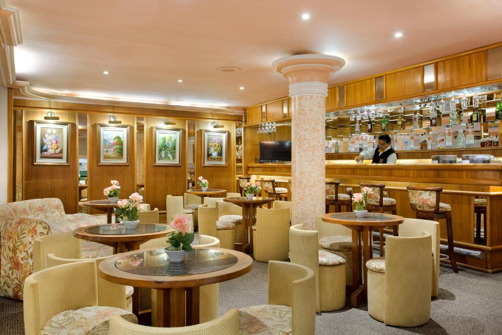 um restaurante com mesas e cadeiras e um bar em Hotel Atlântico Copacabana no Rio de Janeiro