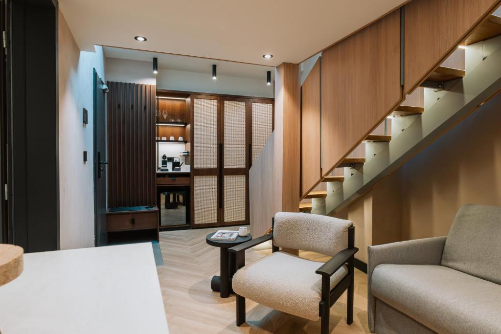 ブカレストにあるホテル トリアノンのリビングルーム(階段、椅子2脚付)