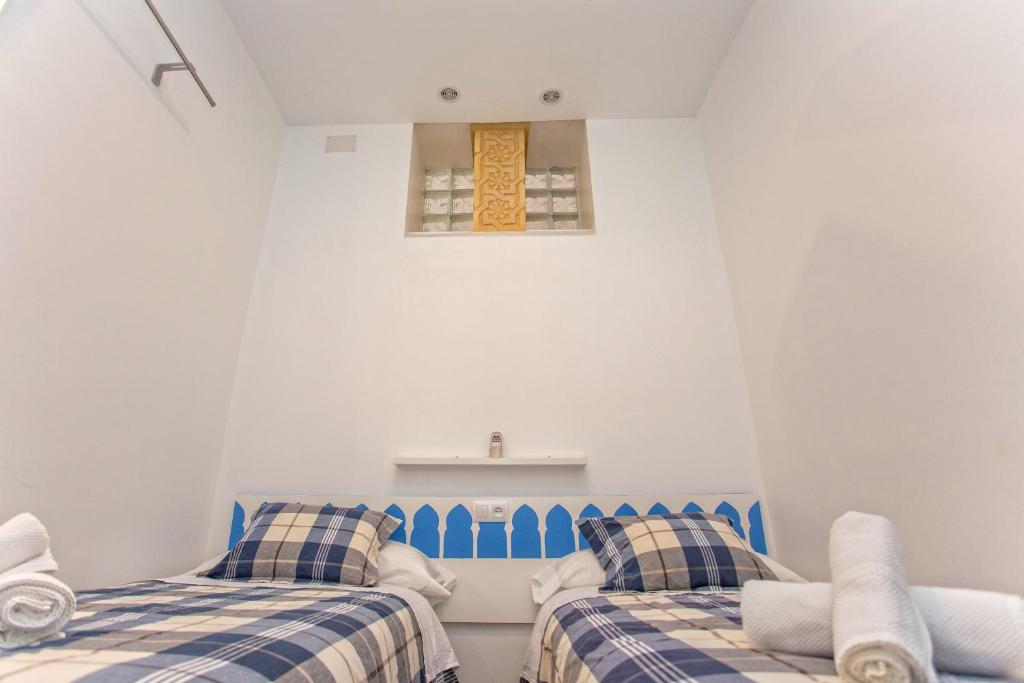 a room with two beds and a chair at Multi Apartamentos La Kasbah in Jerez de la Frontera