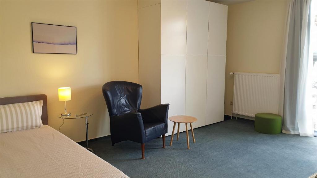 ein Schlafzimmer mit einem Bett, einem Stuhl und einem Tisch in der Unterkunft home31 in Hemmingen