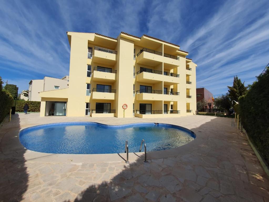 a building with a swimming pool in front of a building at MallorcaRooms Cala Millor in Cala Millor