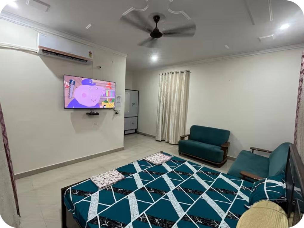 a living room with a bed and a flat screen tv at Himshikha Colony 2bhk in Surajpur