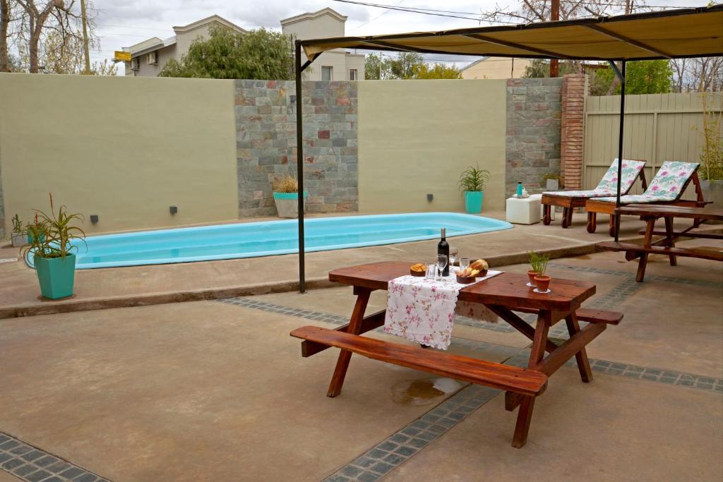 un patio con bancos, una mesa y una piscina en San Rafael Group en San Rafael