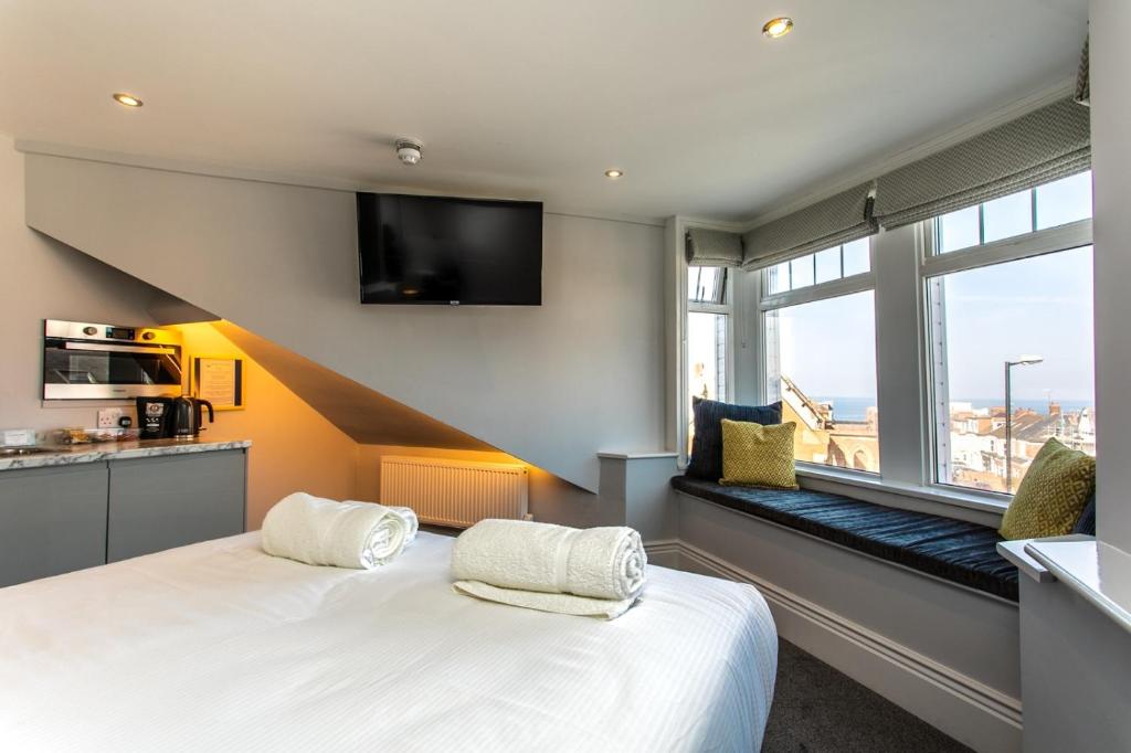 Vacant Nests The linden Hotel Seaside Resort في وايتلي باي: غرفة نوم بها سرير أبيض كبير ونافذة