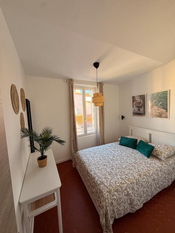 a bedroom with a bed and a table with a potted plant at Jolie T2 dans le centre ville Aubagne in Aubagne