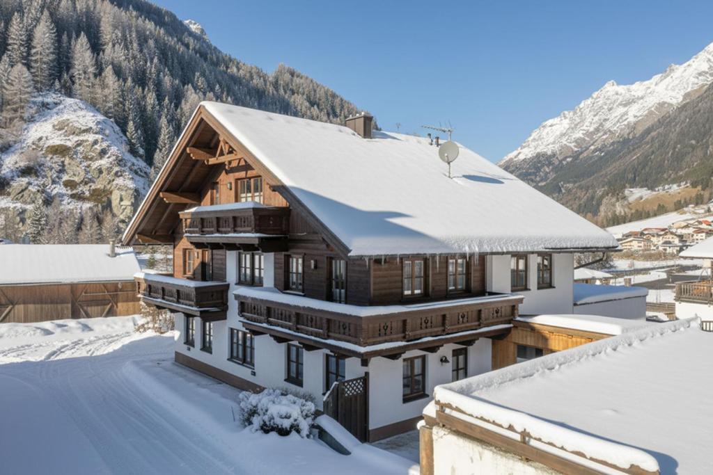 una casa en las montañas con nieve en el techo en Appartements Sonnenstein Sölden, close to lift & centre, en Sölden