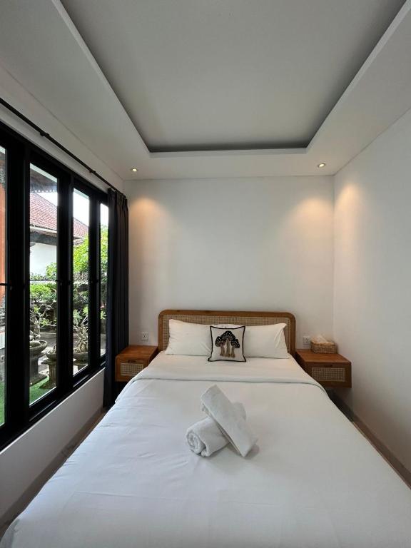 a bedroom with a bed with two towels on it at Kariarta Homestay in Cemagi