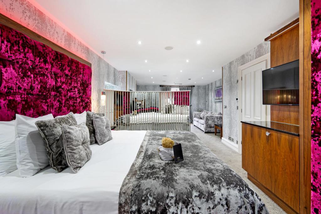 een slaapkamer met een groot bed met een rode muur bij The Cranleigh Boutique in Bowness-on-Windermere