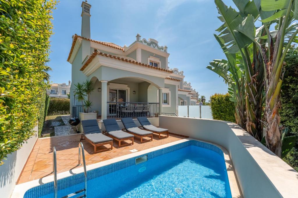 a villa with a swimming pool and a house at Townhouse Sasha in Almancil