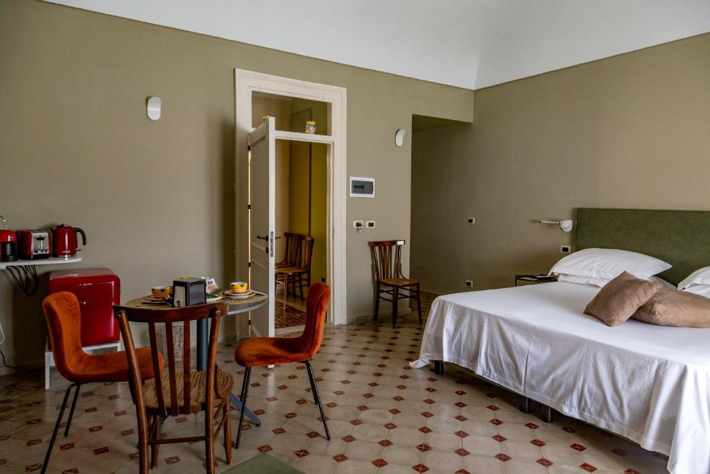 Casa dei Giurati في بالاتسولو أكريدي: غرفة نوم بها سرير وطاولة وكراسي