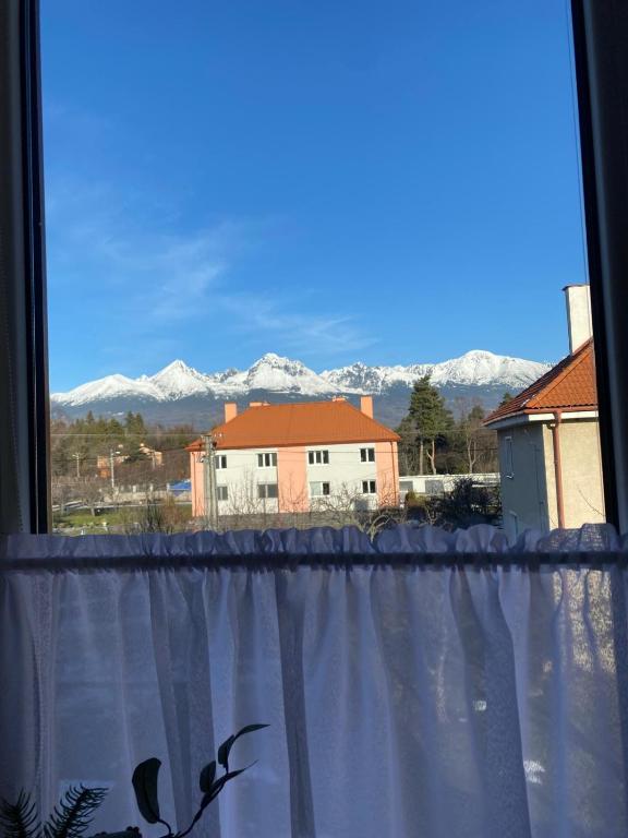 a window with a view of snow covered mountains at Apartmán Jedľa pod Tatrami in Jezersko