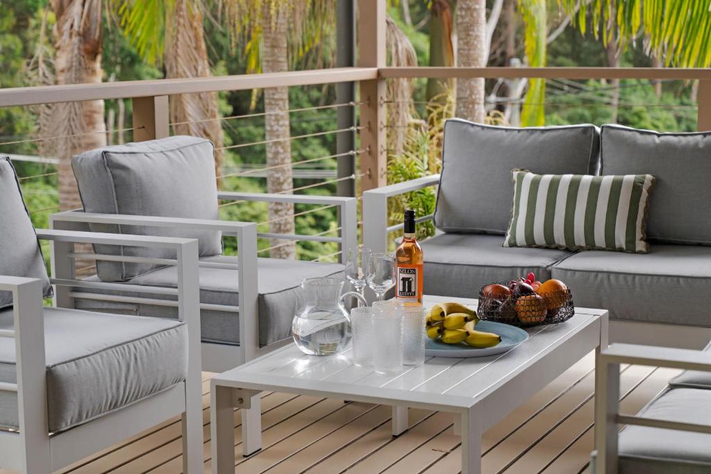 a table with a bottle of wine and fruit on a patio at Simmons Sanctuary Ulladulla in Ulladulla