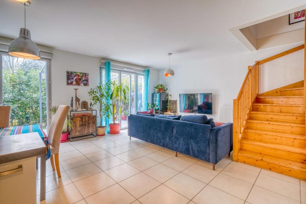 a living room with a blue couch and stairs at Bright house ideal for exploring Bordeaux in Bordeaux