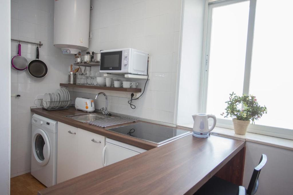 a kitchen with a sink and a washing machine at Multi Apartamentos La Kasbah in Jerez de la Frontera