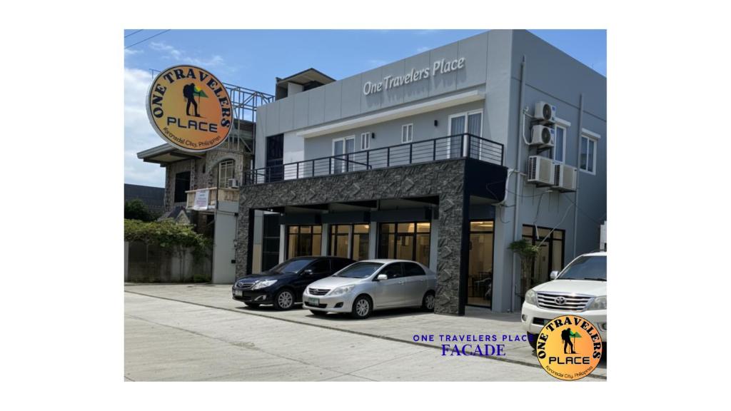 ein Gebäude mit davor geparkten Autos in der Unterkunft One Travelers Place in Koronadal