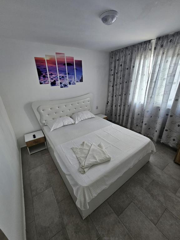 a bedroom with a large white bed with white sheets at Sunshine Costinești in Schitul