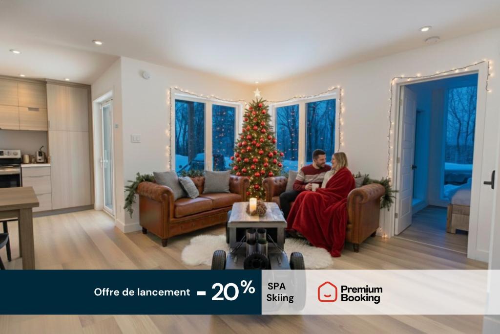 Chalet Luméo Private SPA, Ski في Brownsburg: شخصان يجلسان على أريكة في غرفة معيشة بها شجرة عيد الميلاد