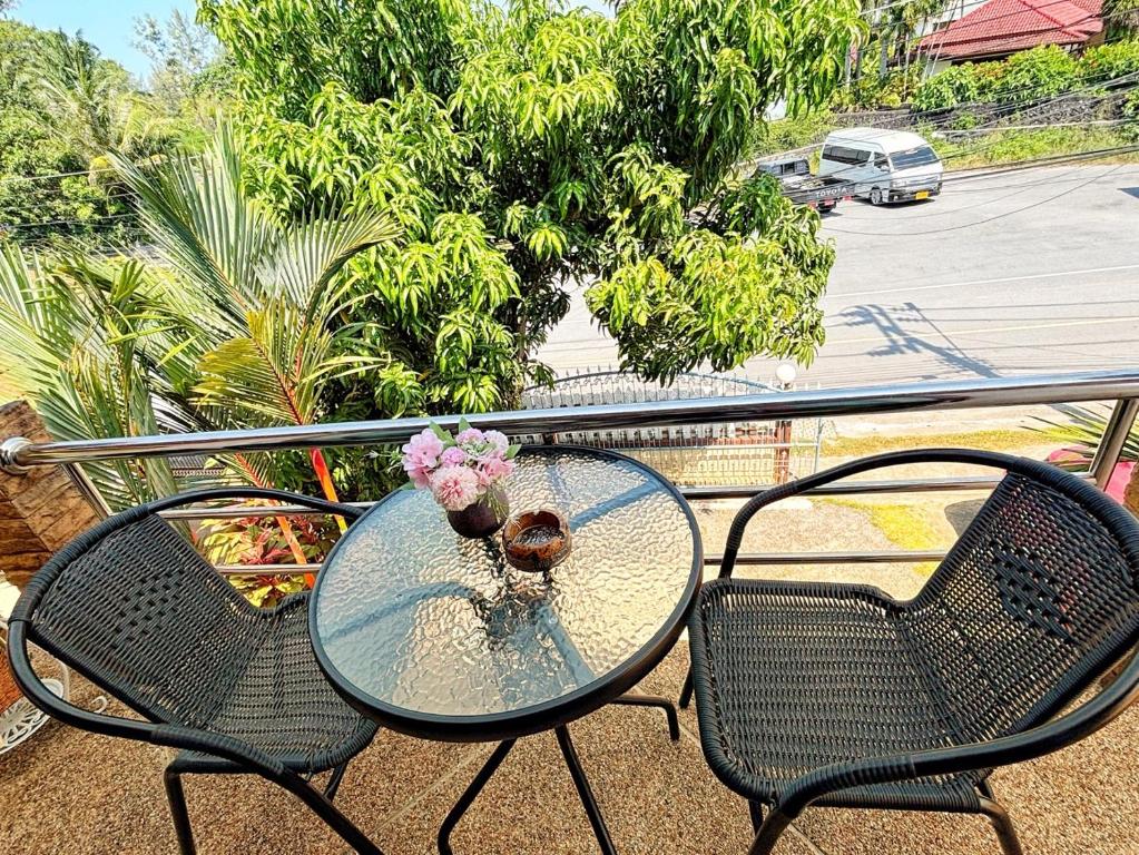 a glass table and two chairs on a balcony at Sachi Home Villa Bangtao - Near Muay Thai and Beach in Ban Thalat Choeng Thale