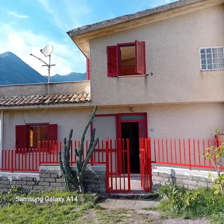 een huis met rode luiken en een rood hek bij Villa Armonia in Spigno Saturnia