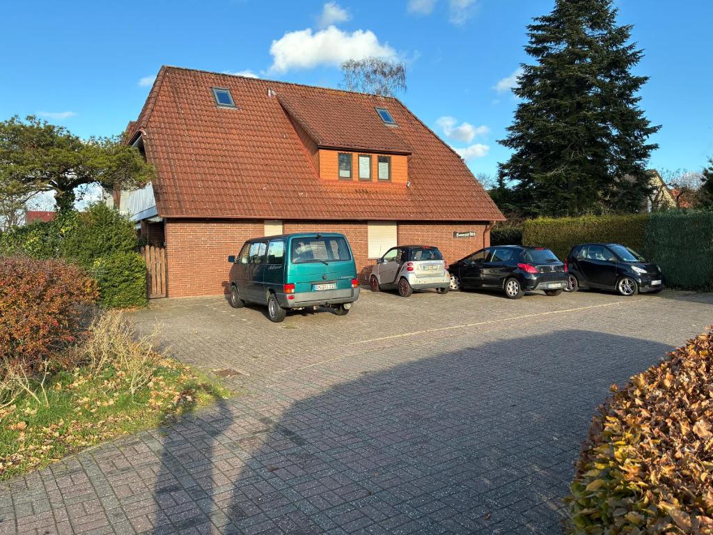 a house with cars parked in a parking lot at Wohnung HaHü in Dangast