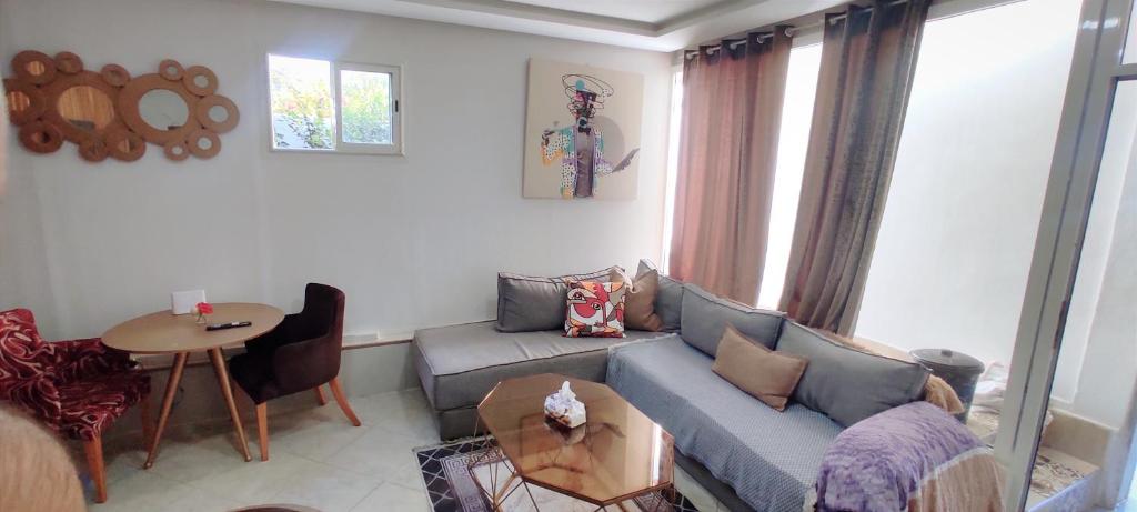 joli studio avec terasse au coeur harhoura في تمارة: غرفة معيشة بها أريكة وطاولة