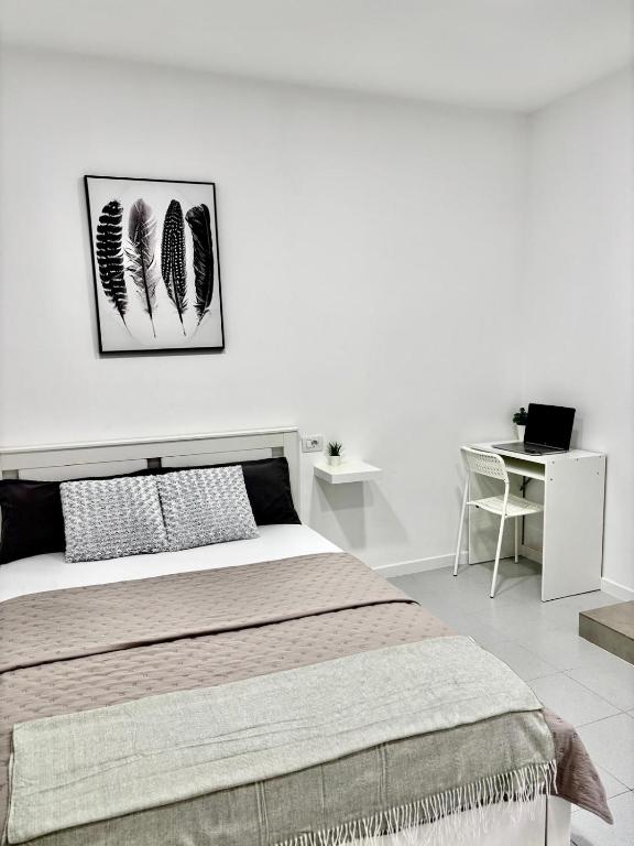 a white bedroom with a bed and a desk at Casa Capitan Coliving Coworking Digital Nomads in San Miguel de Abona