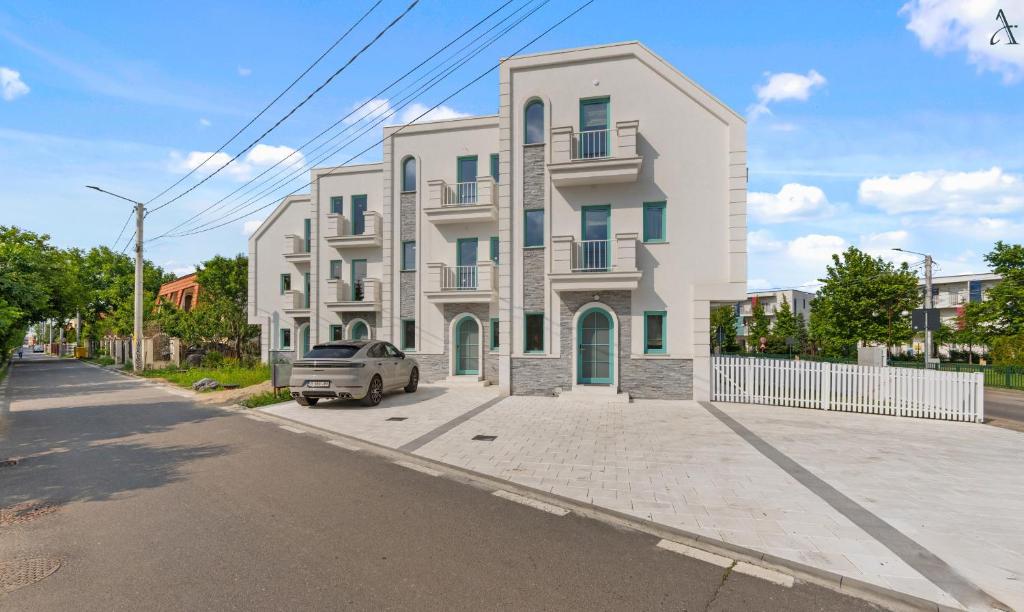 una casa bianca con un'auto parcheggiata davanti di DaVinci Smart Villa a Otopeni