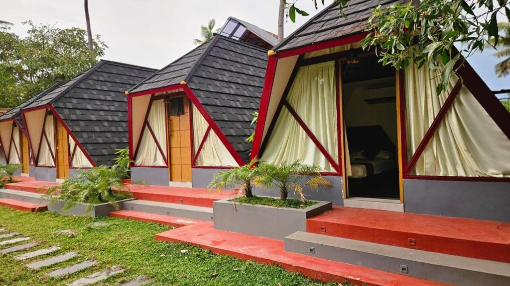 a row of cottages with red steps at Pattaya Village in Kollam