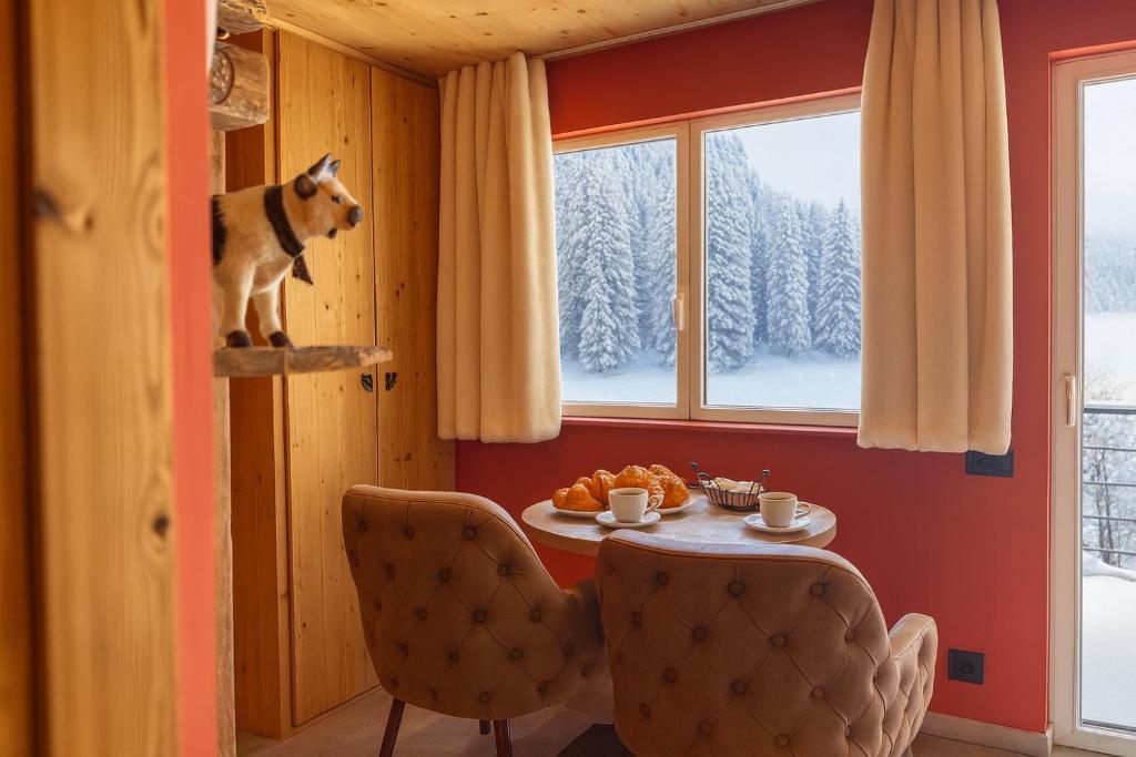 a dog standing on a shelf in a room with a table at Les Secrets - Suites & Apartments in Montriond