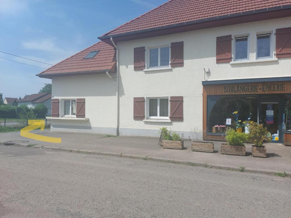 un edificio sul lato di una strada con un negozio di Les Brimbelles a Brû