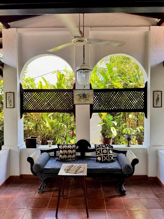 a bench in a room with two large windows at Paddy View Villa in Pedinnoruwa