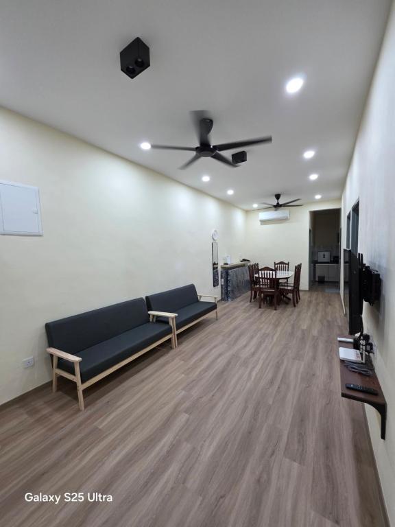 Una sala de estar con un sofá y un ventilador de techo. en Bliss Homestay, en Simpang Ampat