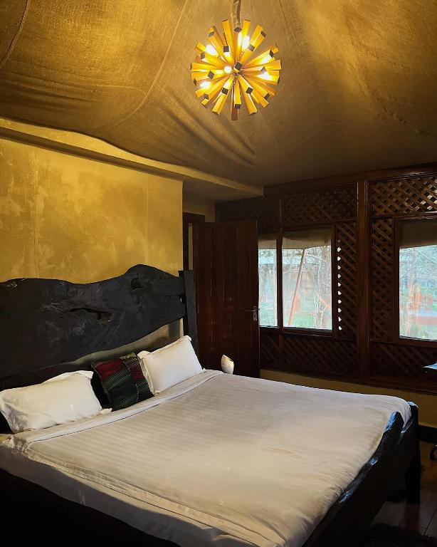 a bedroom with a large bed and a chandelier at Vota Ranch Luxury Stay & Nature Retreat in Machakos