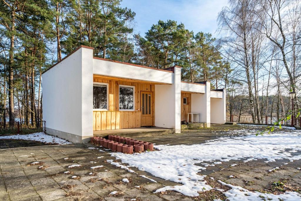une maison dans les bois avec de la neige au sol dans l'établissement Bungalow 6 - Anglerinsel, à Kollm