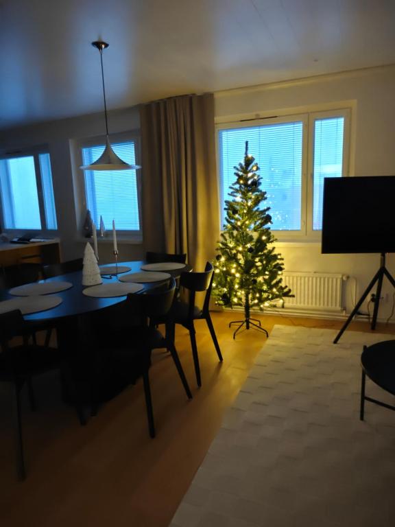 a christmas tree in a living room with a table and chairs at Penthouse Kemi in Kemi