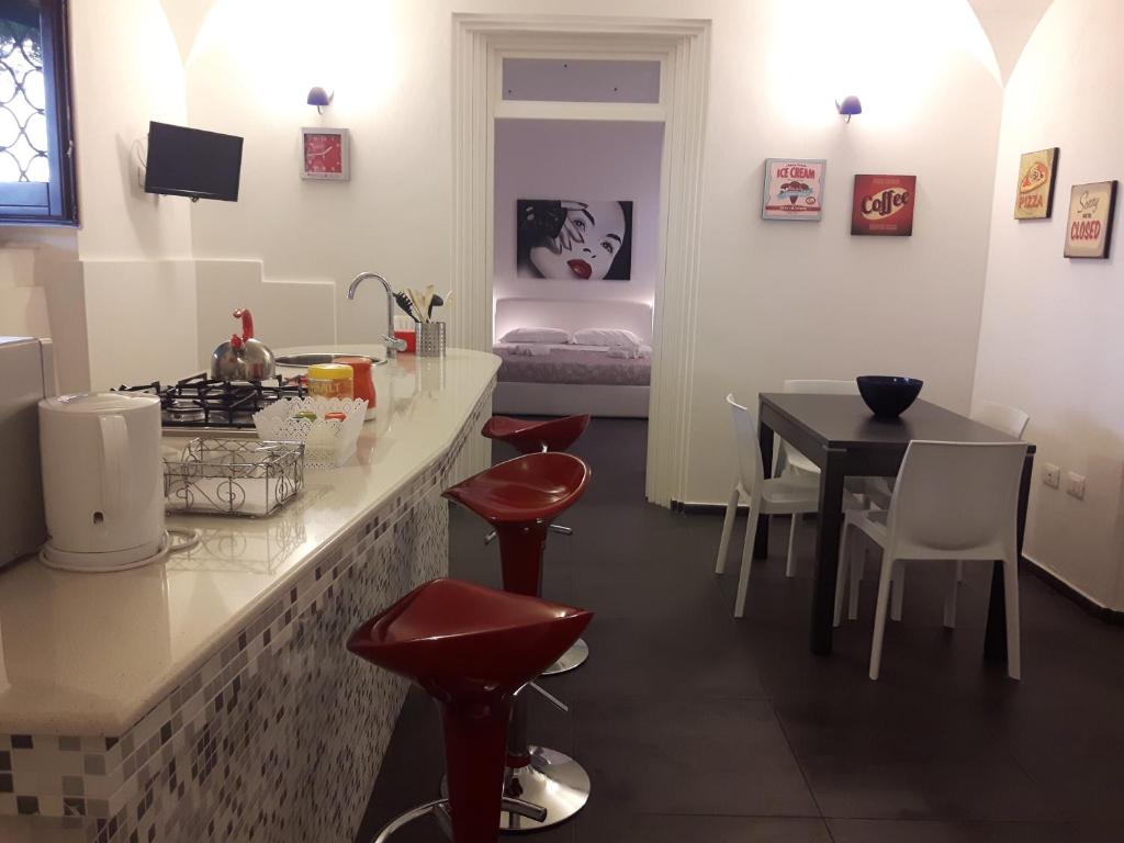 パレルモにあるA un passo dal Massimoのキッチン(テーブル、赤いスツール付)